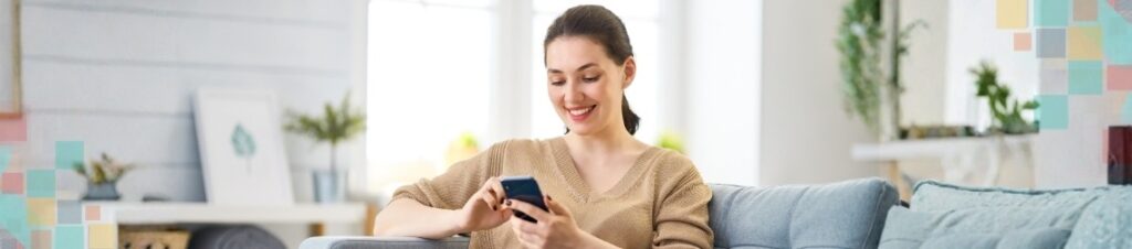 Woman smiling looking at mobile phone.