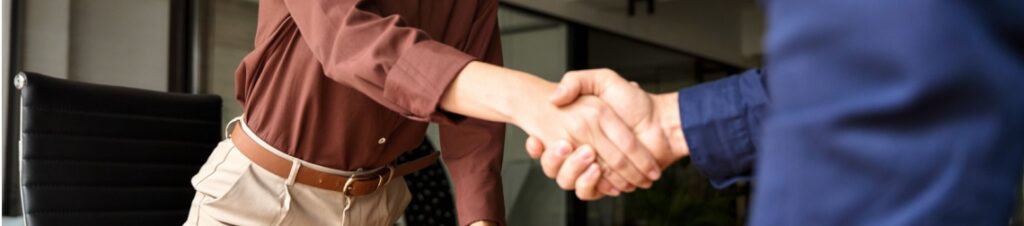 An optometrist and business professional shaking hands during the process of selling their optometry practice.